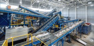 Conveyor belts inside a waste sorting facility, with various types of waste being separated for recycling